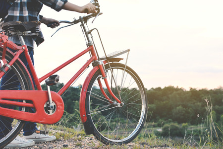 Happy Asian hipster women with bicycle on the road color of vintage tone, Travel on holiday relax time, selective and soft focusの写真素材