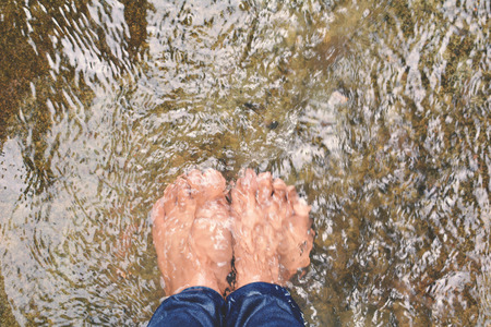 Feet women in river creek ,concept walk in the forestの写真素材