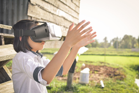 Asian girl playing VR virtual reality glass box ,color of vintage style and soft focusの写真素材