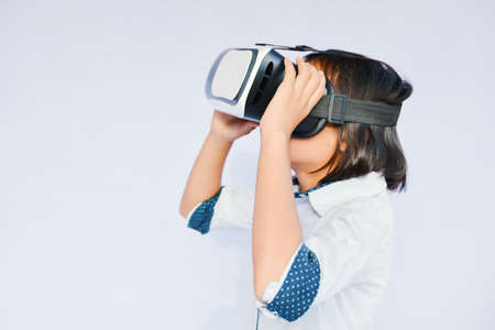 Asian girl playing VR virtual reality glass box on blue background selective and soft focusの写真素材