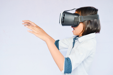 Asian girl playing VR virtual reality glass box on blue background selective and soft focusの写真素材