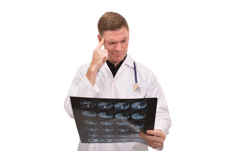 Portrait of young male doctor looking x-ray imaging on white backgroundの写真素材