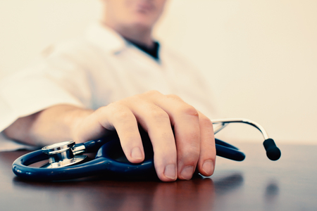 Close up of hand male doctor holding stethoscope color vintage tone selective and soft focusの写真素材