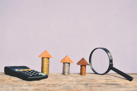 Coin magnifying glass and calculator on wood concept save money for real estateの写真素材