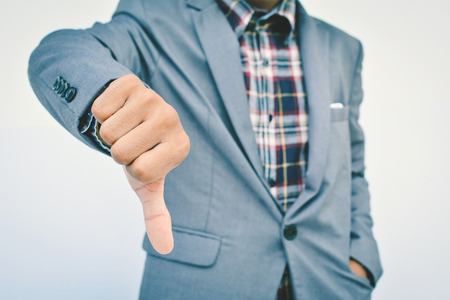 Close up of hand businessman thumbs down  on blue backgroundの写真素材