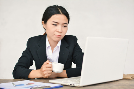 Close up of businesswomen drinking coffee during working in office selective and soft focusの写真素材