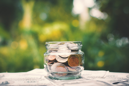 Coin in glass jar on old wood concept save moneyの写真素材