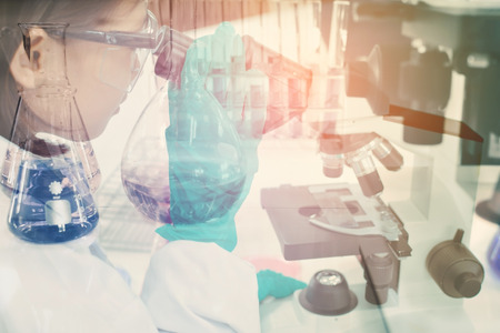 Double exposure of girl using microscope scientific experiment  in the laboratoryの写真素材