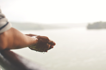 Close up girl hand during rain fall on parkの写真素材