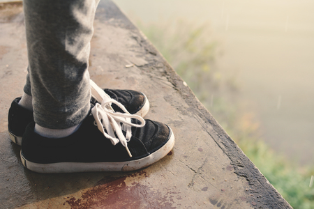 Feet girl standing in park on rainy dayの写真素材