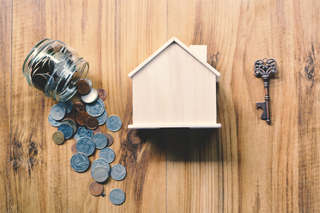 Coins and wood house on table concept save money for home ,selective and soft focus vintage toneの写真素材