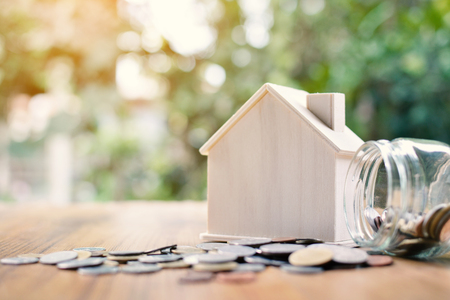 Coins and wood house on table tree bokeh background concept save money for home ,selective and soft focus vintage toneの写真素材