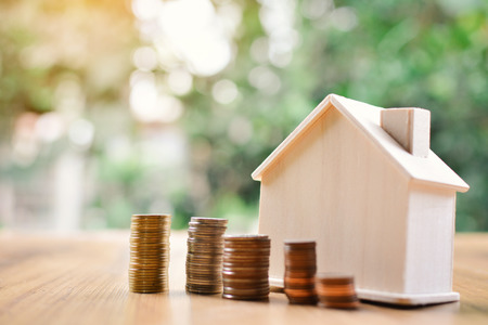 Coins and wood house on table tree bokeh background concept save money for home ,selective and soft focus vintage toneの写真素材