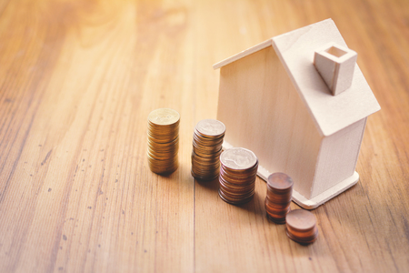 Coins and wood house on table concept save money for home ,selective and soft focus vintage toneの写真素材
