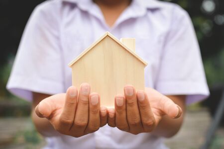 Hands boy holding little wood house selective and soft focus hipster toneの写真素材