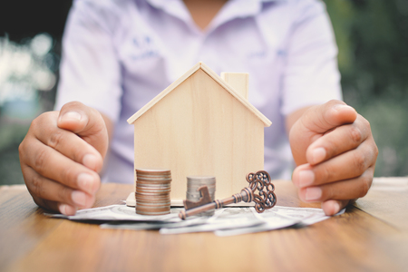 Hands boy holding little wood house and coins concept save money for my home selective and soft focus hipster toneの写真素材
