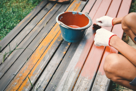 Close up man at work hand holding brush painting on steel selective and soft focus color hipster styleの写真素材