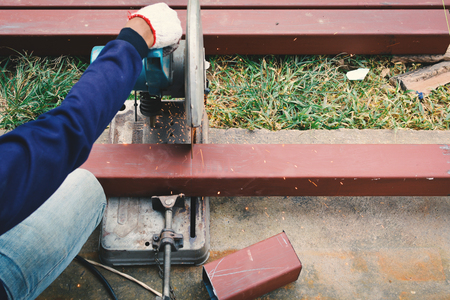 Close up man at work hand holding steel cutter machineの写真素材