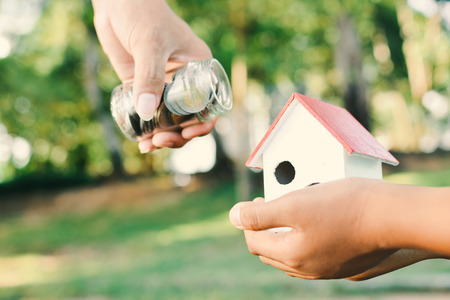 Close up hand giving money bokeh background concept buy my houseの写真素材