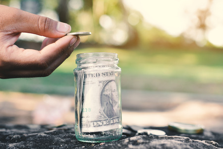 Hand and coins concept save money ,selective and soft focus vintage toneの写真素材