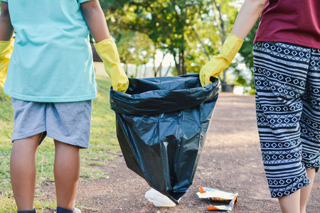 Hands in yellow gloves holding bin bag ,volunteer conceptの写真素材