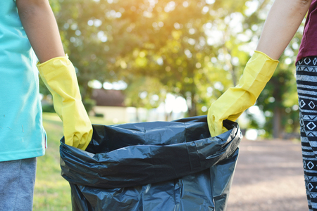 Hands in yellow gloves holding bin bag ,volunteer conceptの写真素材