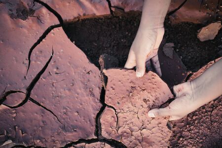 hands of boy holding dry crack background vintage tone,concept droughtの写真素材