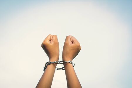 Close up hands in chains concept lack of freedomの写真素材