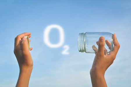 Hands holding glass jar for keeping fresh air Concept of environment and save clean ozoneの写真素材