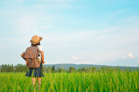 Happy girl backpack in green field , Relax time on holiday concept travelの写真素材