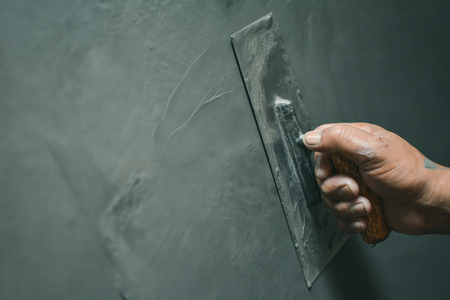 Hand of man working plastering on wallの写真素材