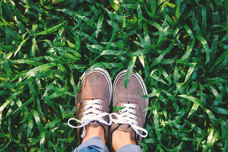 Top view  hipster feet girl on green grass background, Relax time on holidayの写真素材