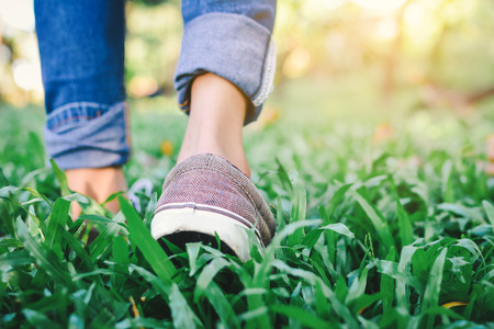 Feet of hipster girl walking in forest background, Relax time on holidayの写真素材