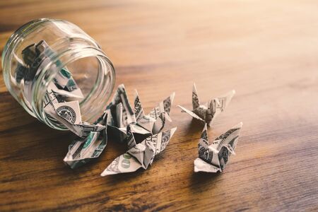 Close up dollar bird in glass jar on wood table, color vintage style ,selective and soft focusの写真素材