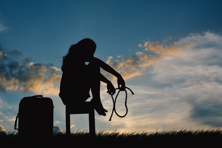 Silhouette of sad women sitting on chair felling discouraged, concept failureの写真素材