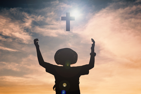 Silhouette of boy open hands and crossの写真素材