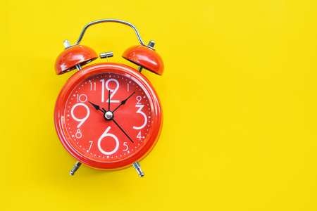 Red alarm clock on yellow backgroundの写真素材