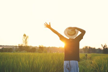 Happy boy open hand on green rice field during sunset ,nature and fresh airの写真素材