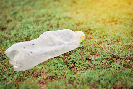 Close-up plastic garbage on green grassの写真素材