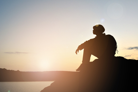 Silhouette of little girl waiting for sunset on top mountain , Happy and relax timeの写真素材