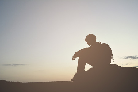 Silhouette of little girl waiting for sunset on top mountain , Happy and relax timeの写真素材