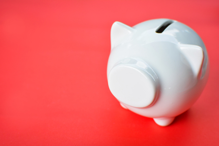 White piggy bank on red background with copy space ,concept save moneyの写真素材