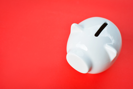 White piggy bank on red background with copy space ,concept save moneyの写真素材