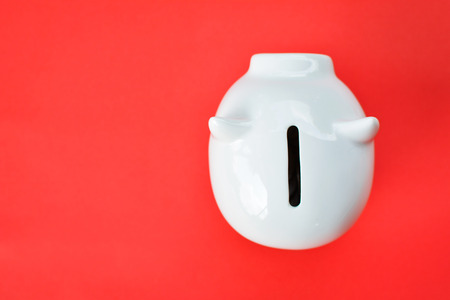 White piggy bank on red background with copy space ,concept save moneyの写真素材