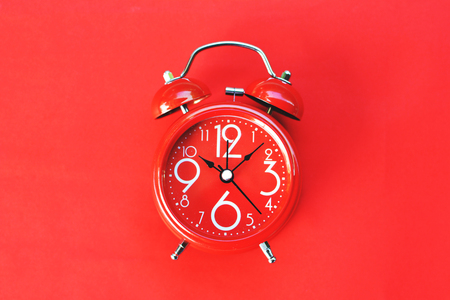 Alarm clock on red backgroundの写真素材