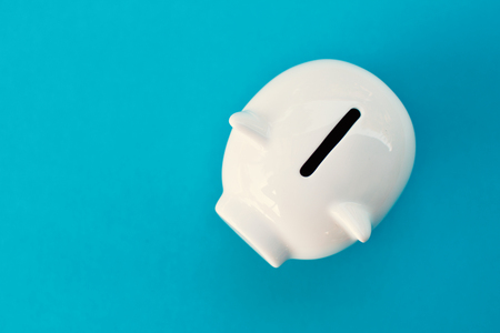 White piggy bank on blue background concept save moneyの写真素材