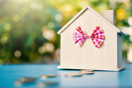 Wood house and coins on table tree bokeh background ,concept save money ,selective and soft focusの写真素材