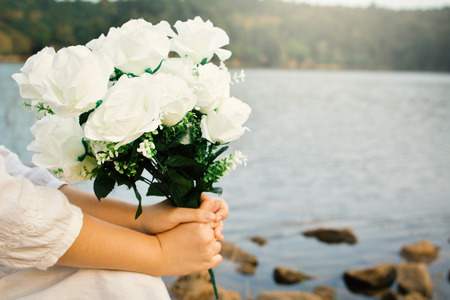 Female hand holding white roses,Concept Valentine's day and weddingの写真素材