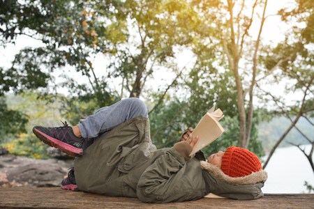 Asian boy reading a book on park in relax time winter seasonの写真素材