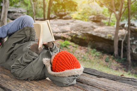 Asian boy reading a book on park in relax time winter seasonの写真素材